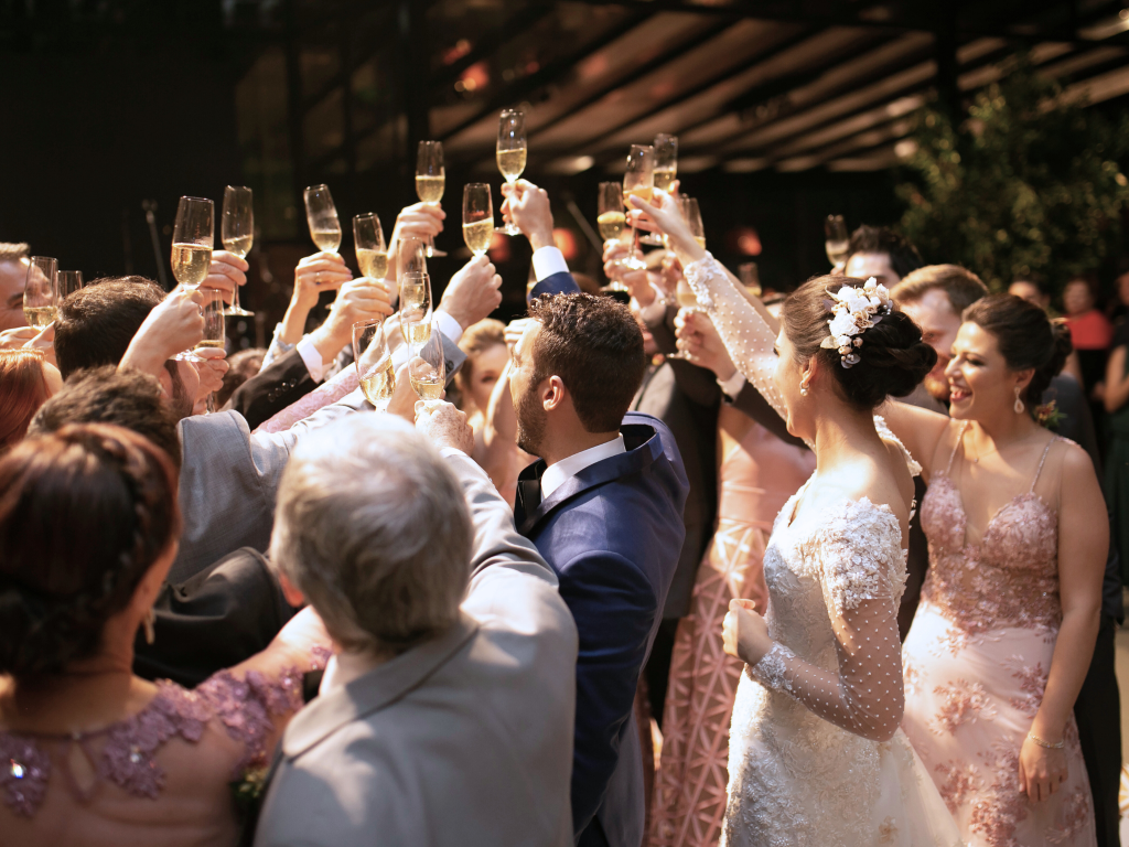 Wedding parties cheers with champagne glasses from their wedding bar hire.