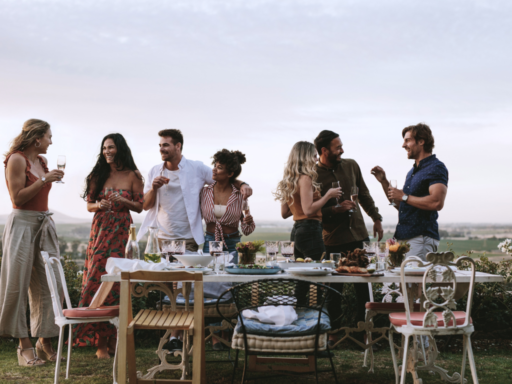 Friends enjoying drinks around a table after being served by our event bar hire service.